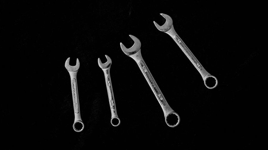 A hand checking tools against a wall at end of day, low light